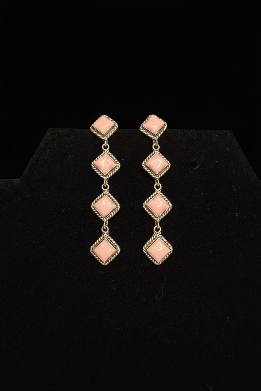 Pair of pink diamond-shaped earrings on a black card with 'Sterling Silver Made in USA' text.